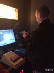 Phil paying shooting game at Ground Kontrol