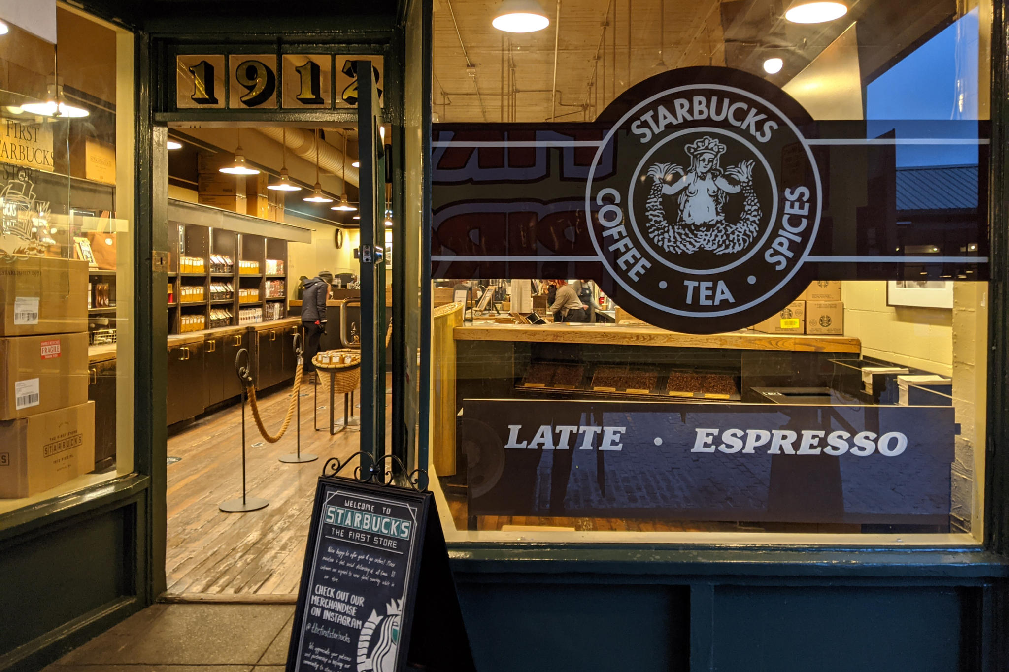 Yellow lights on in an empty orignial Starbucks in the early morning