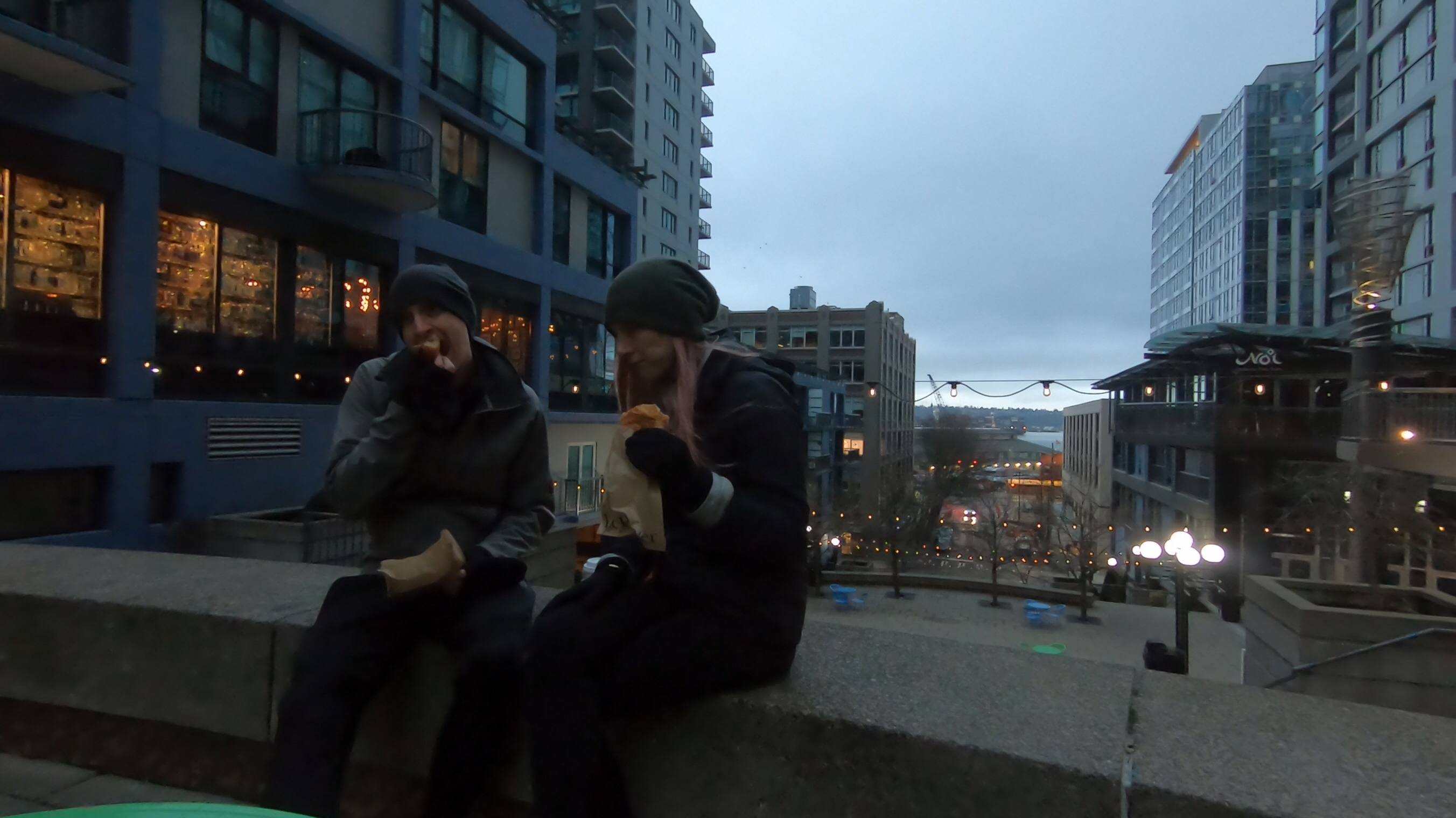 Travel couple sitting on Seattle's Harbor Steps for an early morning breakfast