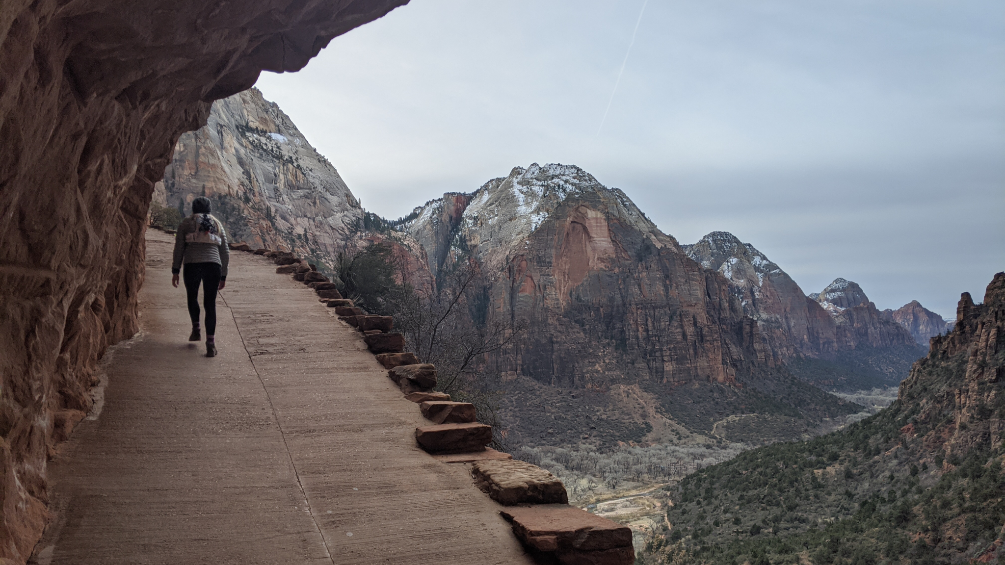 Hiker walking up a steep paved path of the Angels Landing Trail
