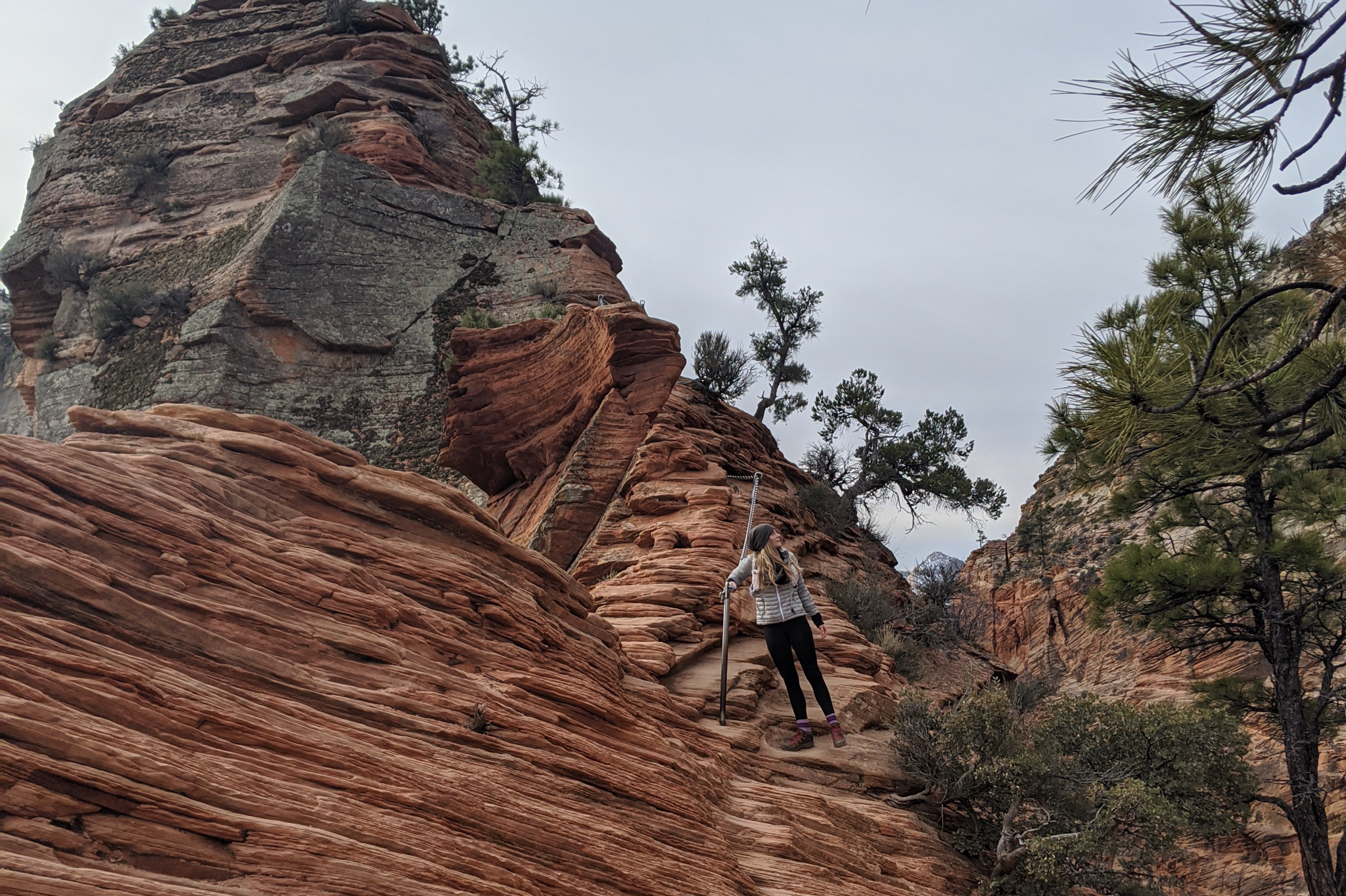 Hiker grabbing onto chains while hiking Angels Landing