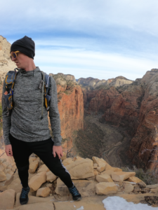 Hiker on the end of a path with the Zion Canyon below