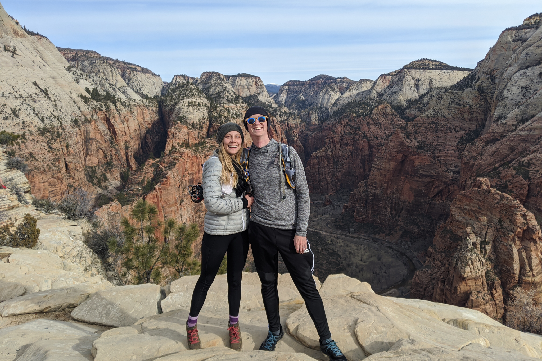 Travel couple at the summit of Angels Landing with the Zion Canyon in the backround