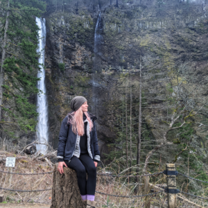 Traveler sitting in front of Multnomah Falls