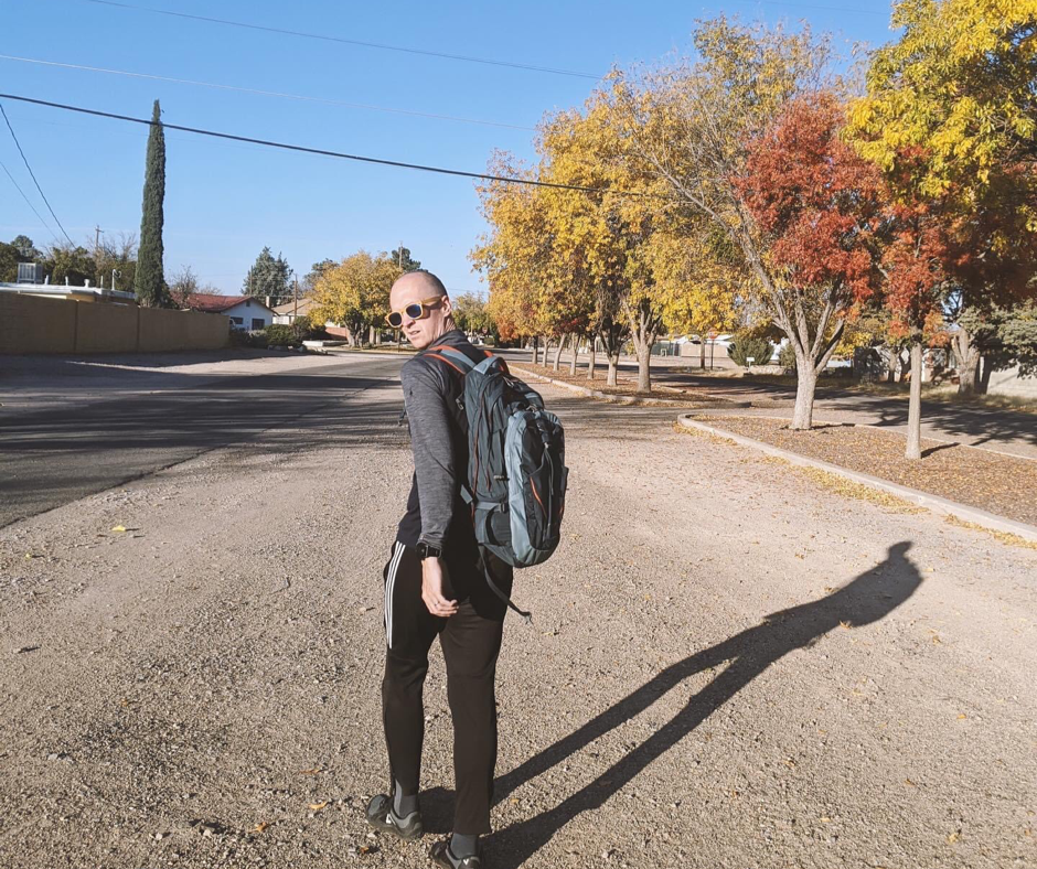 Traveler walking along with a bag on a dirt road